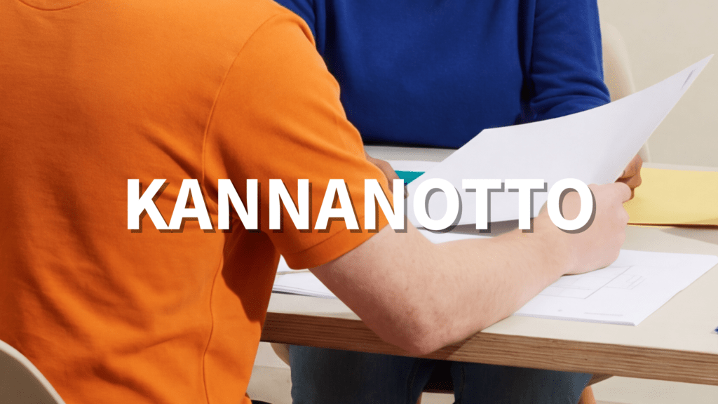 Teksti: Kannanotto Kuva: Kaksi henkilöä pöydän ääressä käymässä läpi papereita.