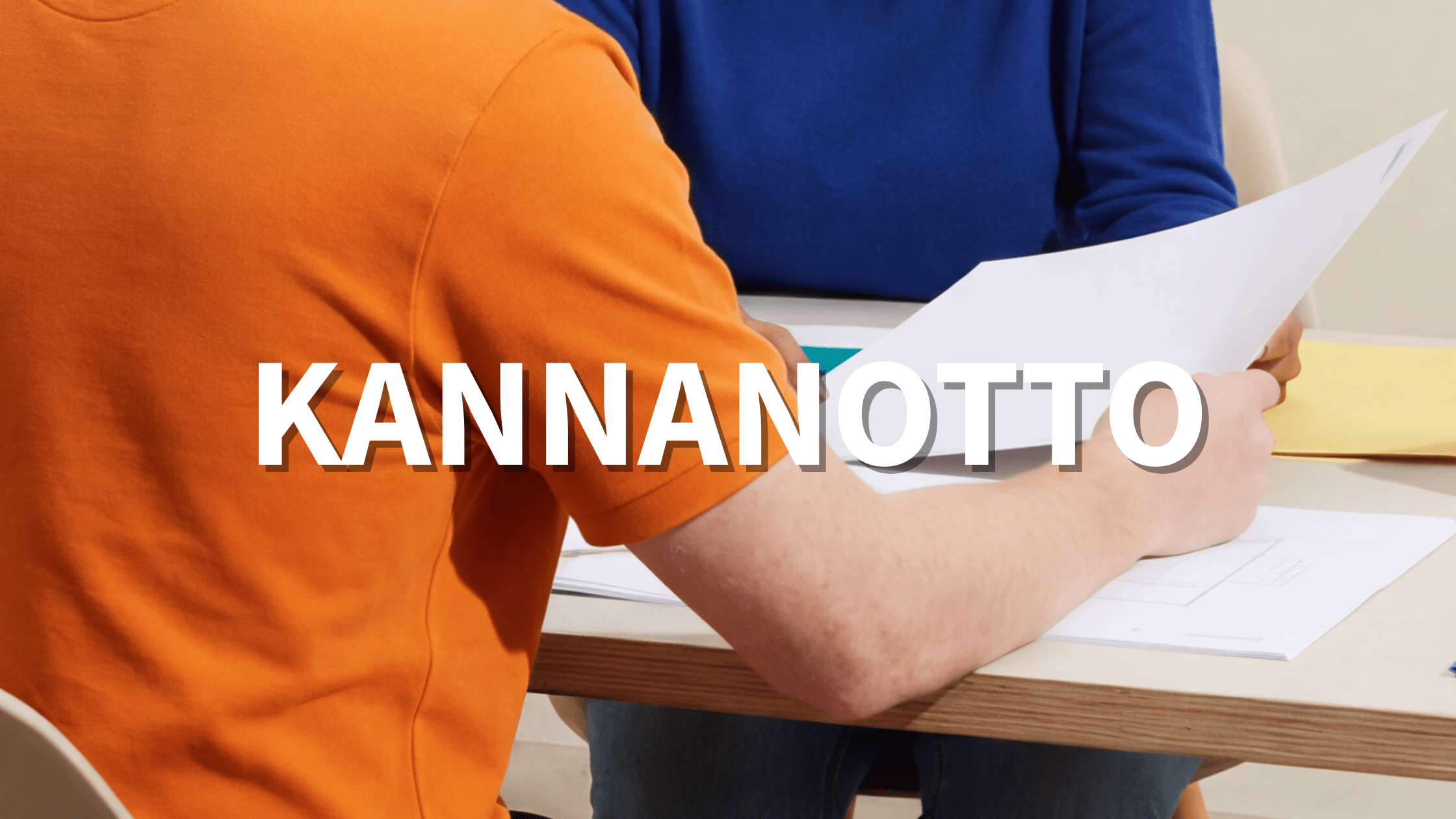 Teksti: Kannanotto Kuva: Kaksi henkilöä pöydän ääressä käymässä läpi papereita.