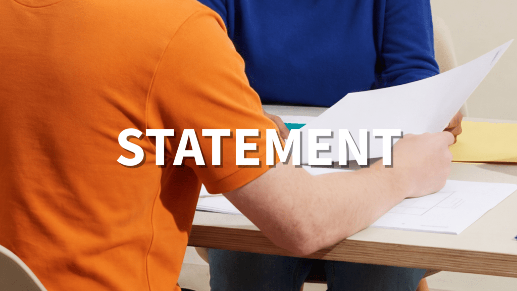 Text: Statement Photo: Two persons sitting and going through papers